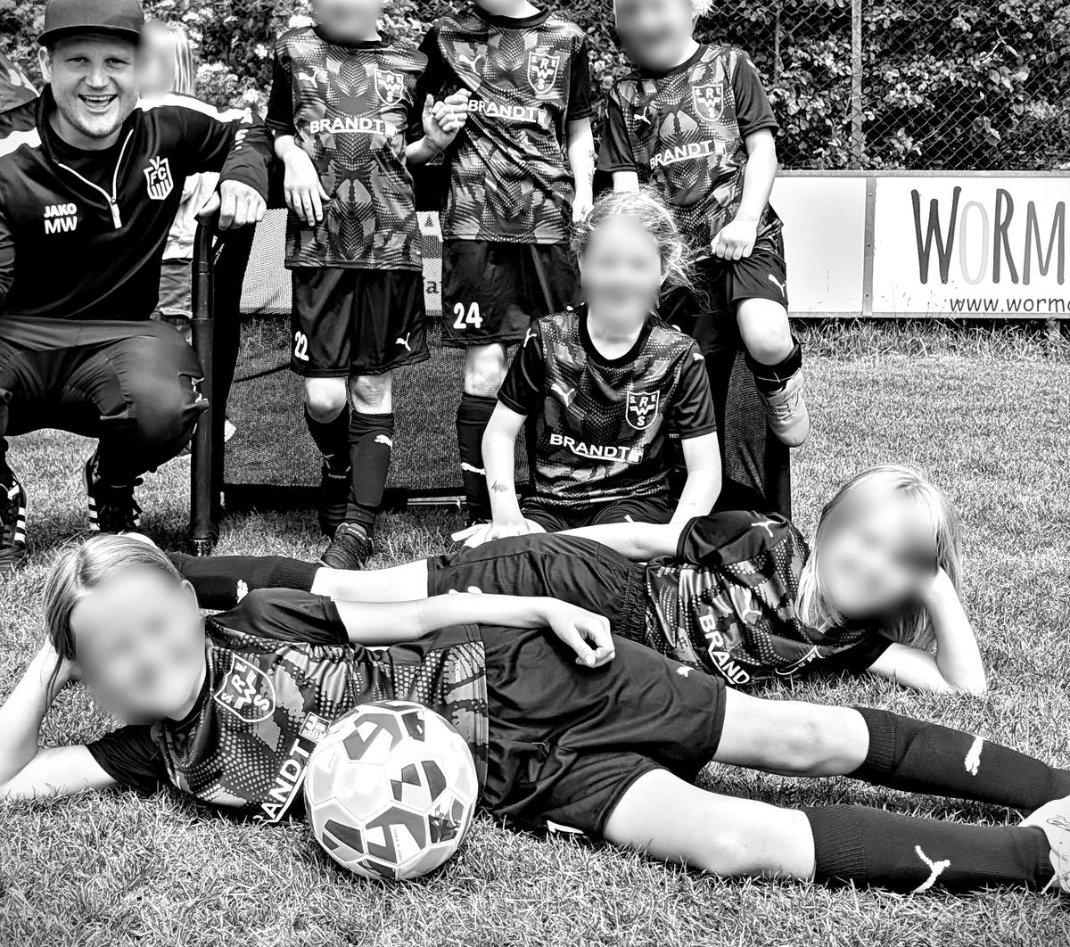 Eine Kindermannschaft des Veeser FC in den schwarz-weißen Trikots, davor ein Ball
