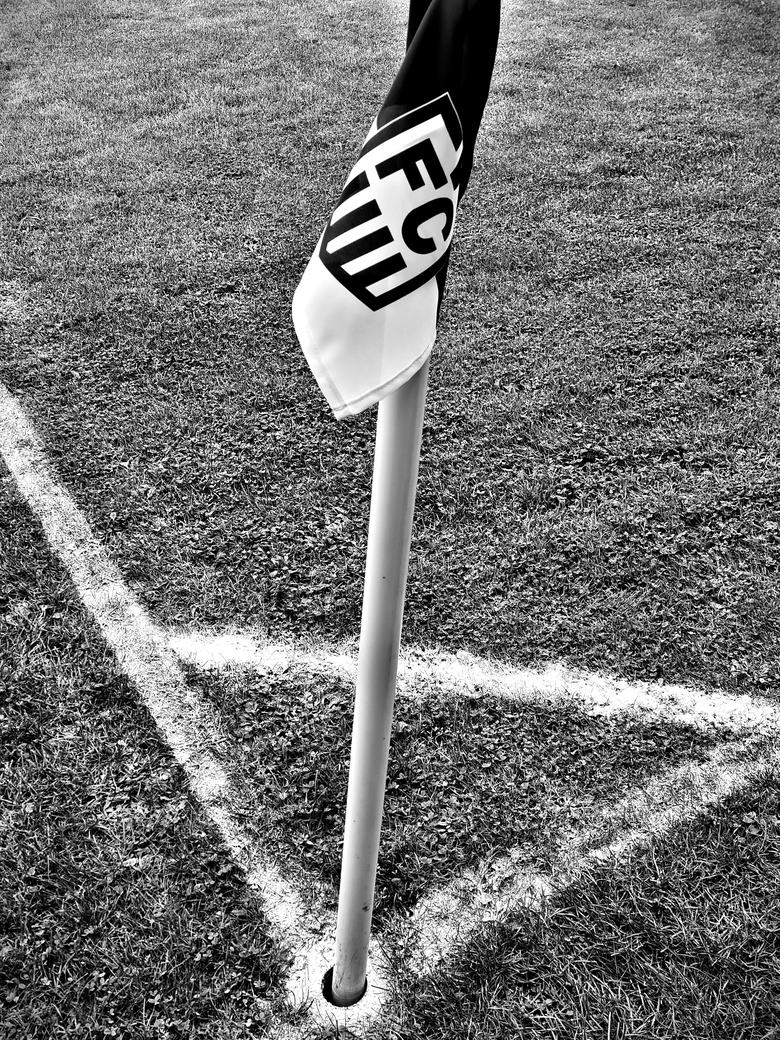 Eckfahne mit dem Wappen des Veeser FC, davor die frisch gezogene Kalklinie